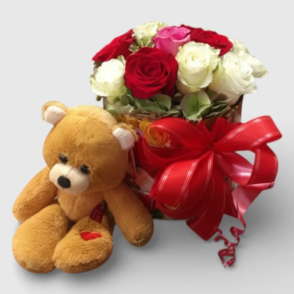 Des roses dans une boîte à chapeau et un ours en peluche