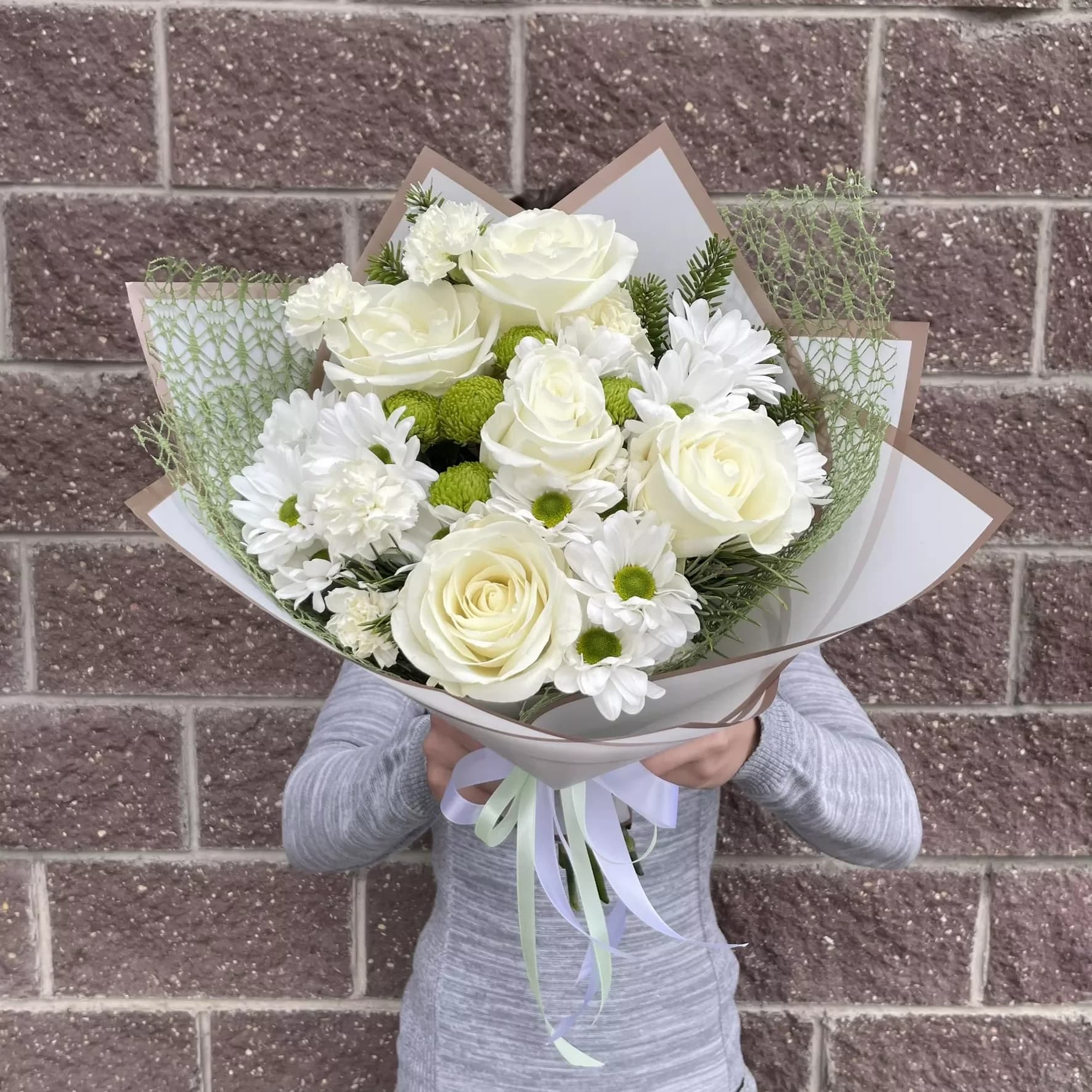 Un bouquet délicat de roses et de chrysanthèmes aux tons blancs
